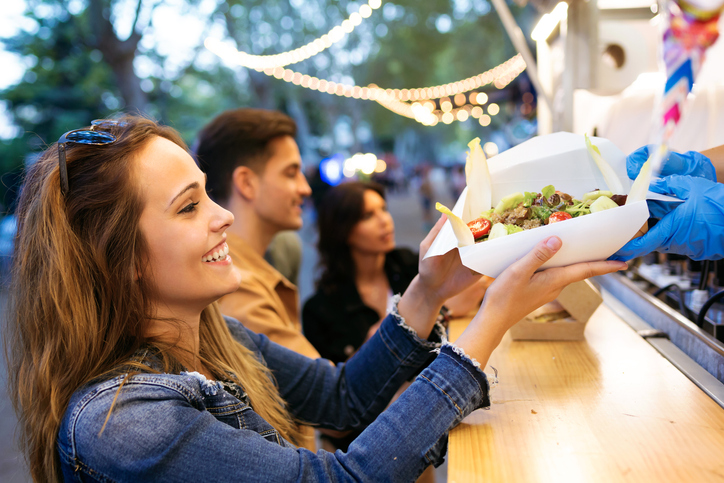 Woman getting the food she ordered from a food stall